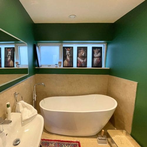Bathroom with dark green walls and white bathtub