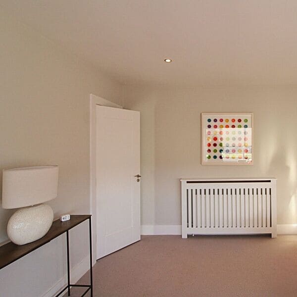 Living room with beige painted walls and ceiling, white radiator, door and woodwork using soft colour drenching